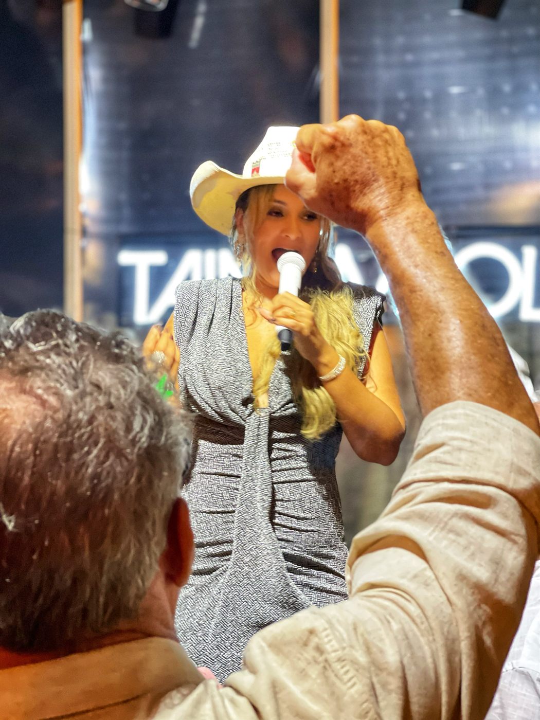Tainá Meoli cantando no meio do público animado