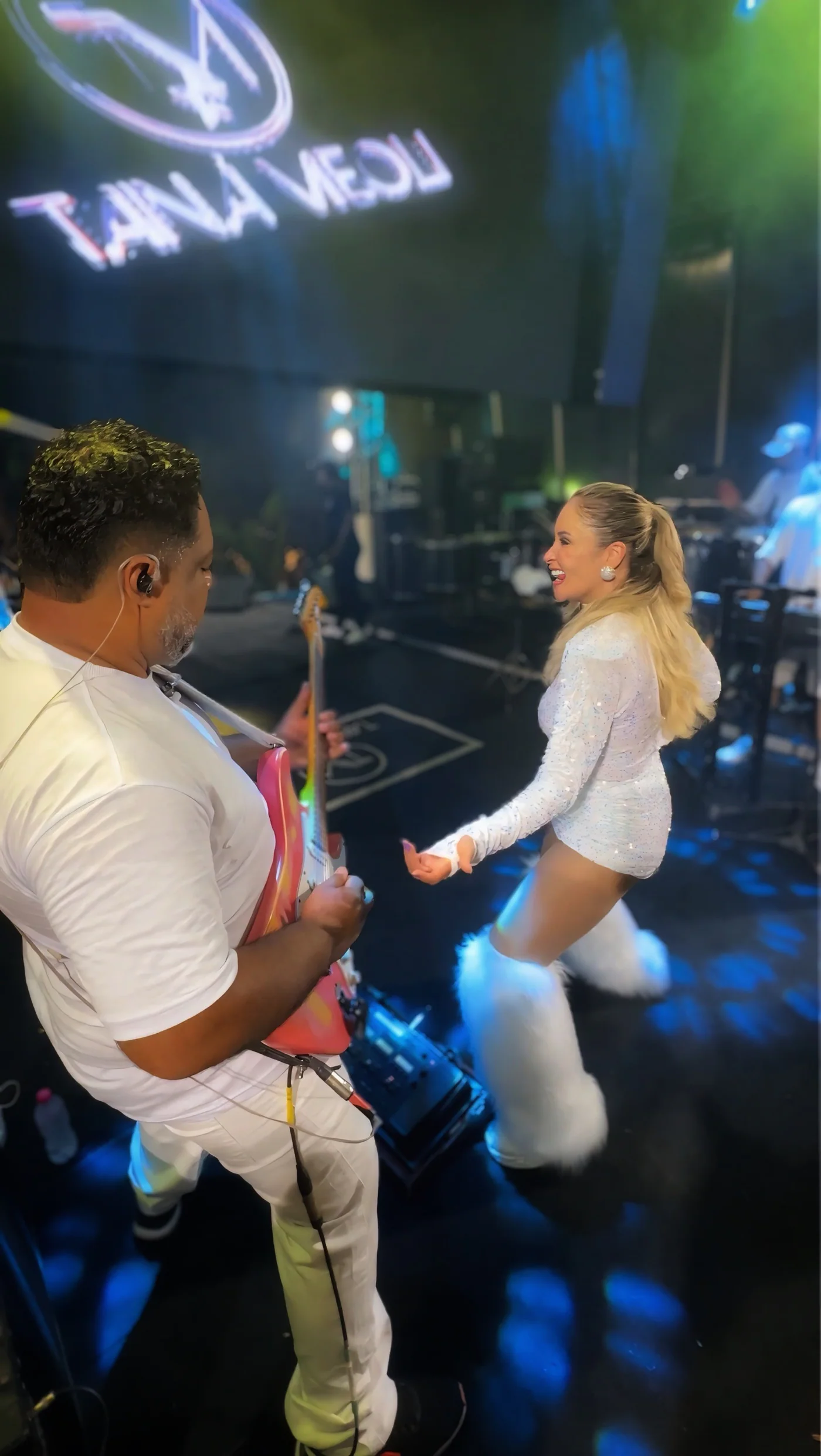 Tainá interagindo com o guitarrista durante um show